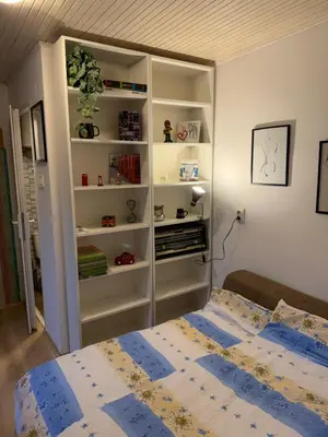a bedroom with a bed and a book shelf at Kutak in Podgorica