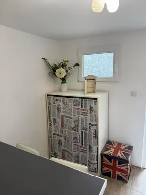 a room with a newspaper on a refrigerator with a window at Kutak in Podgorica