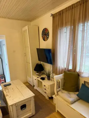 a living room with a couch and a desk with a television at Kutak in Podgorica