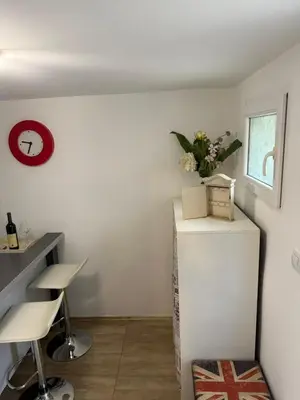 a room with a refrigerator and a table and chairs at Kutak in Podgorica