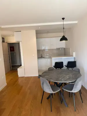a dining room with a table and chairs and a kitchen at Oaza Bar 1 in Bar