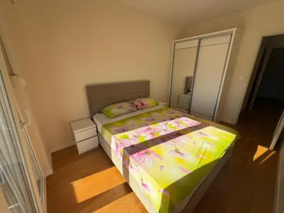 a small bedroom with a bed with a large mirror at Oaza Bar 1 in Bar