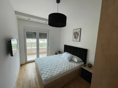 a bedroom with a bed and a large window at Montenegro Black Suite in Podgorica