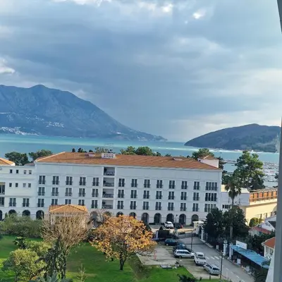 a large white building in front of the water at New sea view luxury apartment in center in Budva