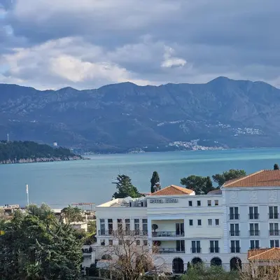 a building with a statue on top of it next to the water at Sea view luxury apart in Tq plaza in Budva