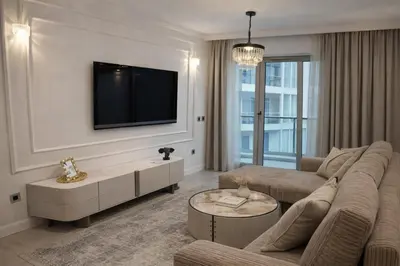 a living room with a couch and a tv on a wall at Sea view luxury apart in Tq plaza in Budva