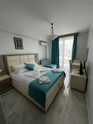a bedroom with a large bed and a window at Bilali Apartments in Ulcinj