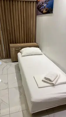 a bed in a room with white sheets on it at Bilali Apartments in Ulcinj