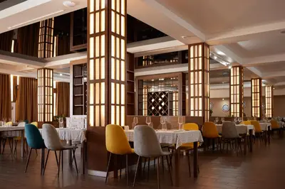 a dining room with tables and chairs and windows at Azul Beach Resort Montenegro by Karisma - All Inclusive in Ulcinj