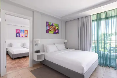a white bedroom with a bed and a window at Azul Beach Resort Montenegro by Karisma - All Inclusive in Ulcinj