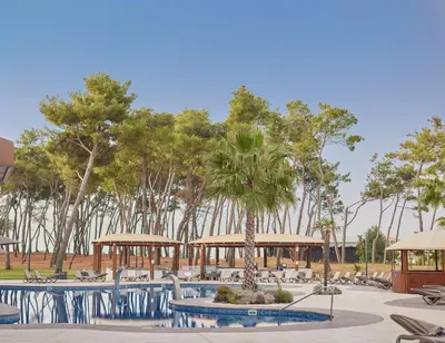 a resort with tables and chairs and trees at Azul Beach Resort Montenegro by Karisma - All Inclusive in Ulcinj