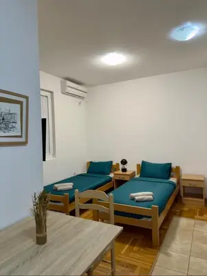 a living room with two blue couches and a table at ADAIST Apartments Budva Free Parking & Balcony in Budva