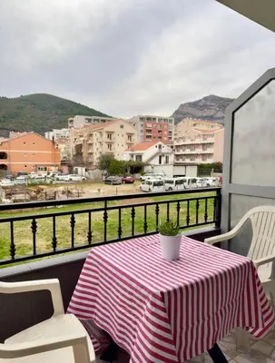 a table on a balcony with a view of a city at ADAIST Apartments Budva Free Parking & Balcony in Budva