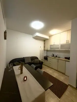 a kitchen and living room with a table and a couch at ADAIST Apartments Budva Free Parking & Balcony in Budva