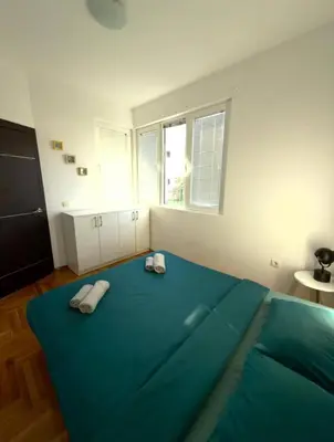 a bedroom with a large blue bed with towels on it at ADAIST Apartments Budva Free Parking & Balcony in Budva