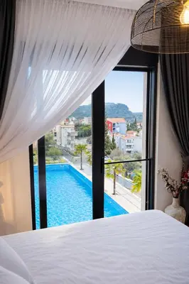 a bedroom with a bed and a view of a swimming pool at Olive apartments in Petrovac na Moru