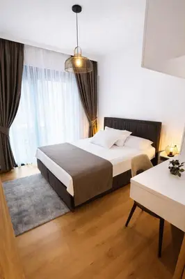 a bedroom with a large bed and a table at Olive apartments in Petrovac na Moru