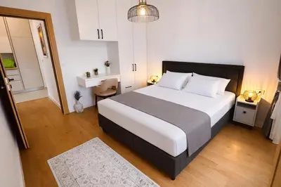 a bedroom with a large bed with white sheets at Olive apartments in Petrovac na Moru
