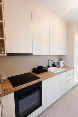 a kitchen with white cabinets and a black sink at Olive apartments in Petrovac na Moru
