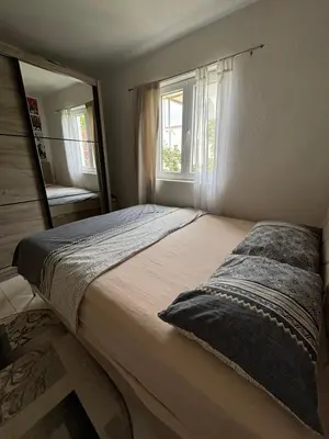 a bedroom with a large bed and a mirror at Radon apartments in Dobra Voda