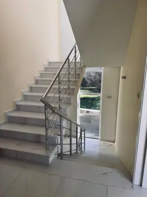 a staircase with a metal railing in a house at Sea Whisper Villa in Dobra Voda
