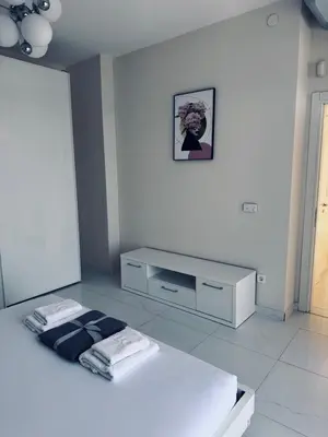 a white room with a bed and a desk at Sea Whisper Villa in Dobra Voda