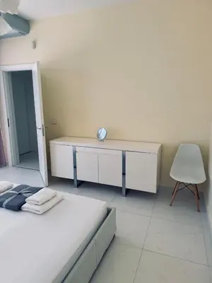 a bedroom with a bed and a desk and a chair at Sea Whisper Villa in Dobra Voda