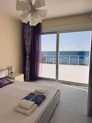 a bedroom with a bed with a view of the ocean at Sea Whisper Villa in Dobra Voda
