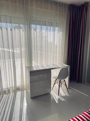 a desk and a chair in a room with windows at Sea Whisper Villa in Dobra Voda