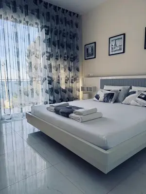 a large white bed in a room with curtains at Sea Whisper Villa in Dobra Voda