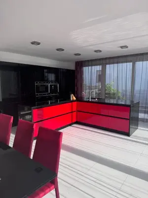 a kitchen with red cabinets and a table and chairs at Sea Whisper Villa in Dobra Voda