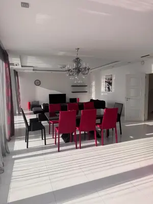 a dining room with a table and red chairs at Sea Whisper Villa in Dobra Voda