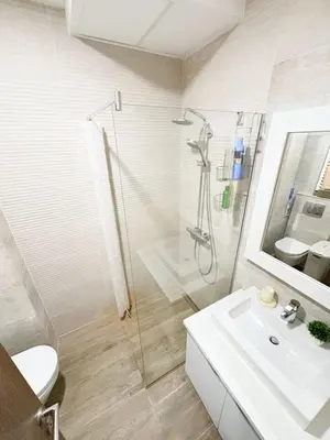 a white bathroom with a shower and a sink at Flat in Budva with terrace and private garden in Budva