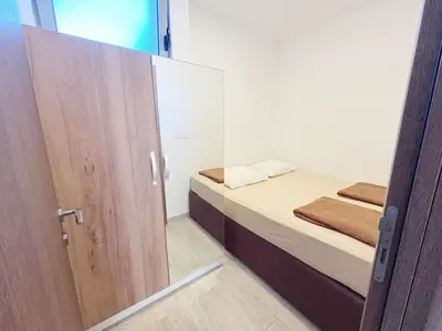 a small bedroom with a bed and a mirror at Flat in Budva with terrace and private garden in Budva