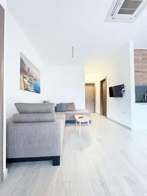 a white living room with a couch and a table at Flat in Budva with terrace and private garden in Budva