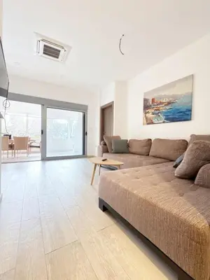 a living room with a couch and a table at Flat in Budva with terrace and private garden in Budva