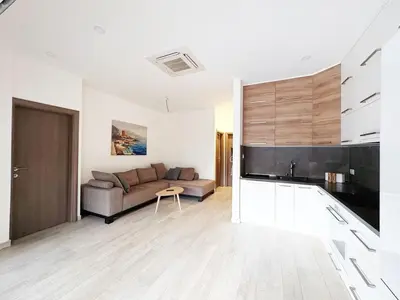 a living room with a couch and a table at Flat in Budva with terrace and private garden in Budva