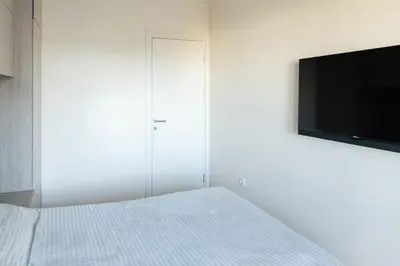 a bedroom with a bed and a flat screen tv at Tramonto City Center Apt with Sea View and Garage in Bar