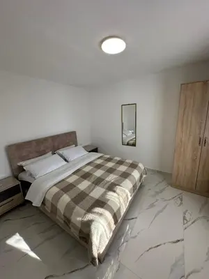 a bedroom with a large bed with a plaid blanket at Ani Sea Lux in Dobra Voda