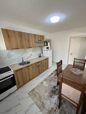 a kitchen with wooden cabinets and a table and a tableablish at Ani Sea Lux in Dobra Voda