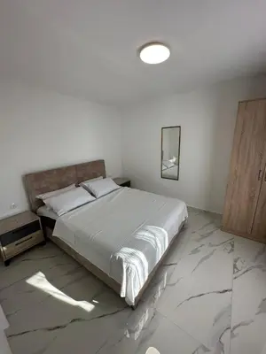 a bedroom with a large bed with a marble floor at Ani Sea Lux in Dobra Voda