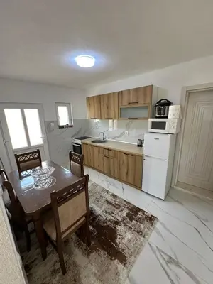 a kitchen with a table and chairs and a white appliance at Ani Sea Lux in Dobra Voda