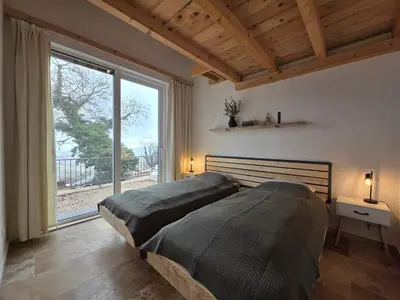 two beds in a bedroom with a large window at Sunrise Villa in Bar