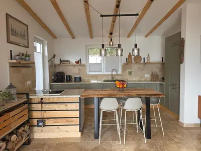 a kitchen with a large wooden table and white stools at Sunrise Villa in Bar