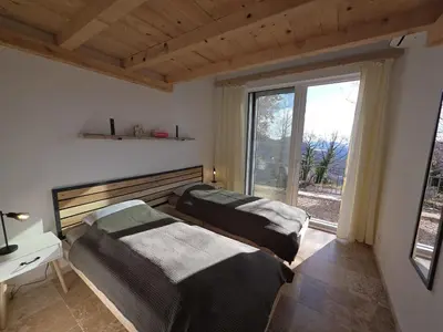 two beds in a room with a window at Sunrise Villa in Bar