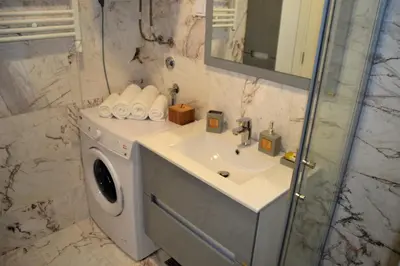 a bathroom with a washing machine and a sink at Yeshill Deluxe Apartment in Budva