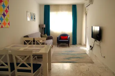 a living room with a couch and a table and a television at Yeshill Deluxe Apartment in Budva