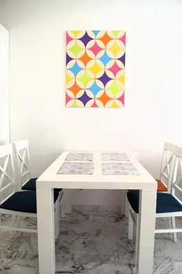 a white table with chairs and a painting on the wall at Yeshill Deluxe Apartment in Budva