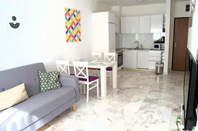 a living room with a couch and a table and a kitchen at Yeshill Deluxe Apartment in Budva