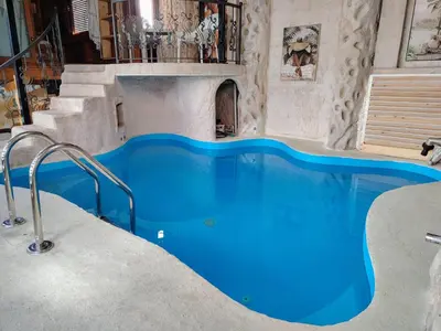 a swimming pool in a house with a blue pool at Hedonizam Lux in Podgorica